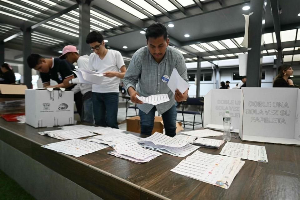 Trabajadores electorales se preparan para empezar a contar votos en la elección de Ecuador.