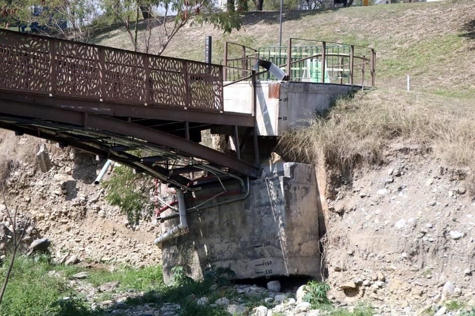 Una de las bases de un puente peatonal que cruza el arroyo se deslizó hacia un lado, por el deslave en el talud.