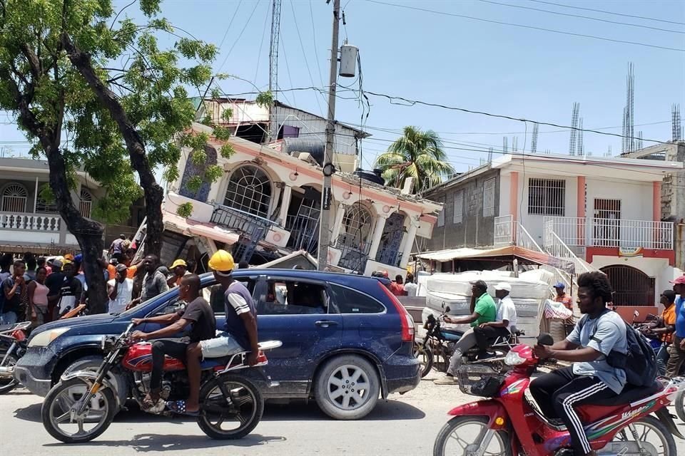 Personas circulan frente a un hotel derrumbado por el sismo en Haití.