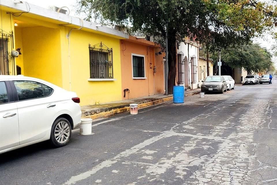 En la calle Libertad, vecinos 'apartan' espacios con tambos de basura y cubetas a los largo del día.