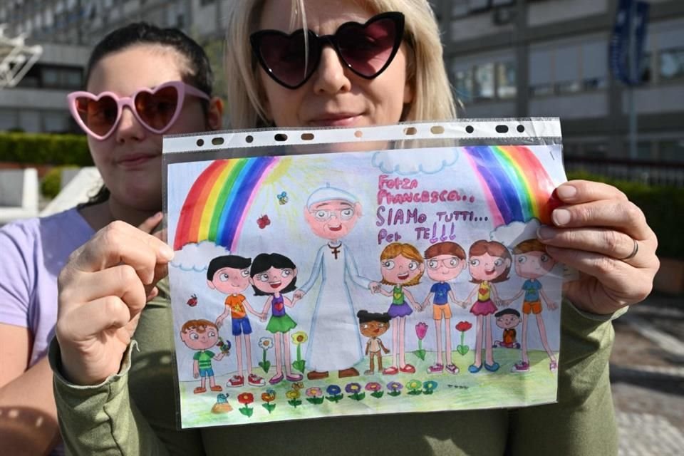 Violetta, de Polonia, y su hija María con un dibujo para el Papa Francisco afuera del hospital Gemelli, donde el Papa Francisco está internado.