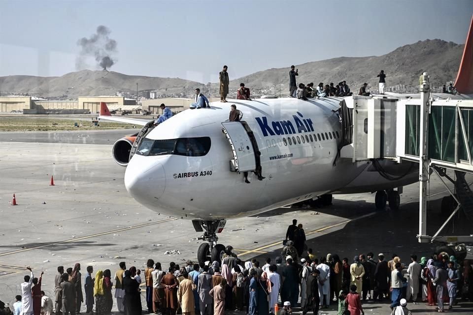 Personas trepan a un avión en medio del caos para huir de Kabul.