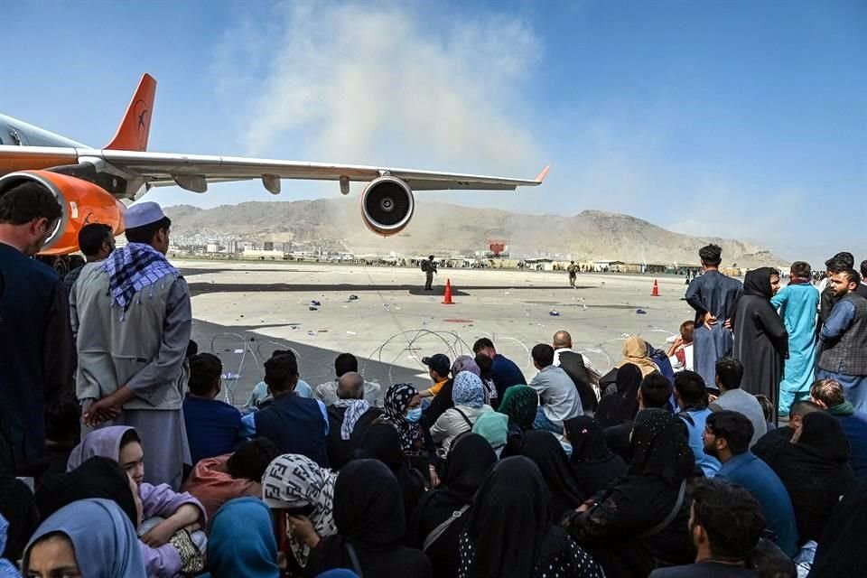 Afganos en el aeropuerto de Kabul descansan mientras esperan para salir del país.