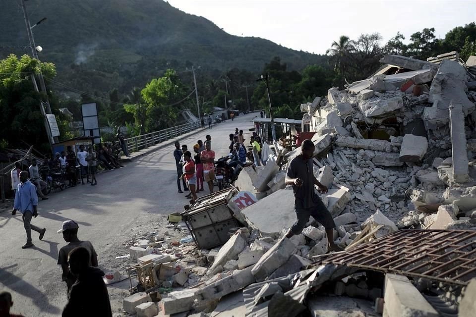 Un hombre camina encima de un edificio colapsado en Saint-Louis-du-Sud, Haití.