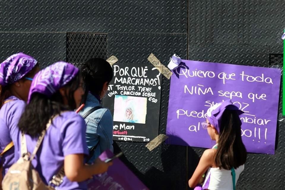 Mujeres y niñas comenzaron a colocar carteles en la valla alrededor del Palacio de Gobierno.