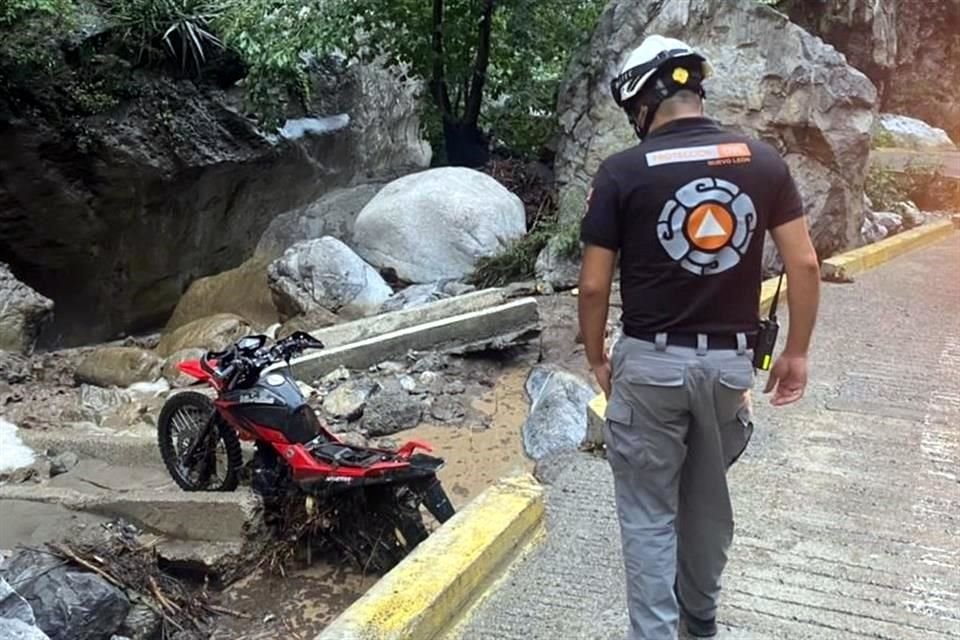 Los rescatistas de Protección Civil encontraron una de las motos que fue arrastrada por la corriente, en la sierra de Santiago.
