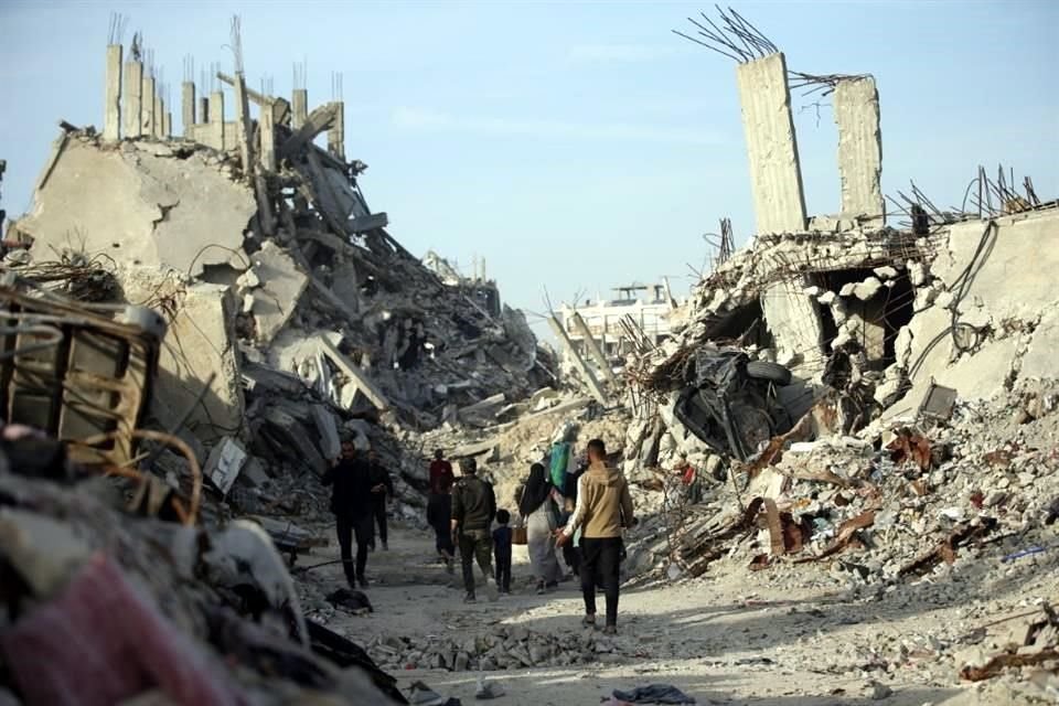Imagen del 17 de marzo de 2025 de palestinos caminando entre edificios destruidos, en Jabalia, en el norte de la Franja de Gaza.