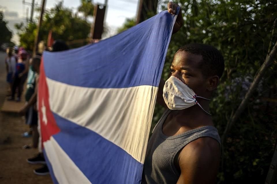 Un hombre en Cuba despliega una bandera para recibir a un grupo de doctores cubanos, en junio de 2020.