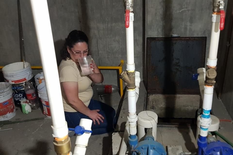 La vecina Georgina Riva Palacio, hace un año, mostrando un recipiente con agua contaminada.
