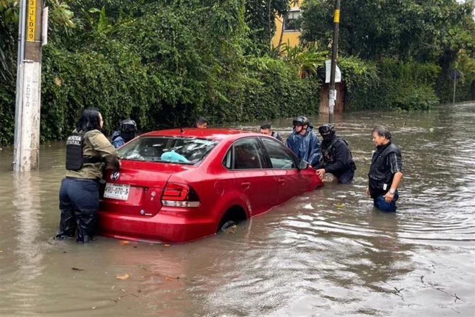 En la colonia Mártires de Chicago, en Xalapa, policías brindan auxilio en calles inundadas.