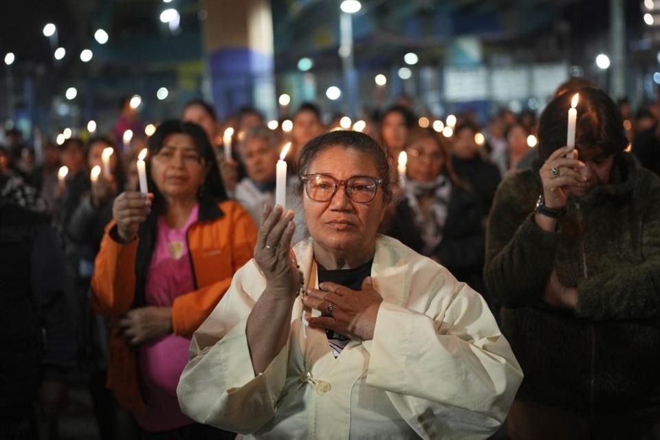 Fieles sostienen velas durante una misa en honor al Papa Francisco en Buenos Aires.