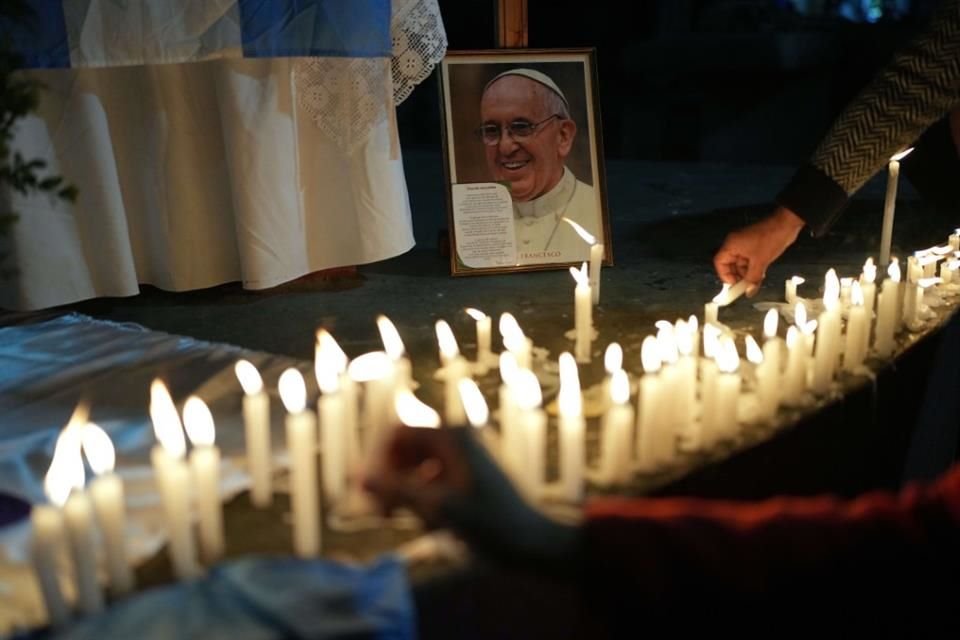 Fieles encienden velas durante una misa debajo de un puente en Buenos Aires.