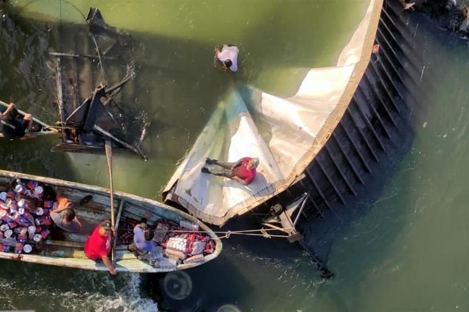 Pobladores bucearon para hacer rapiña de mercancía que transportaba un camión que cayó en río en Tabasco, tras accidente que dejó un muerto.