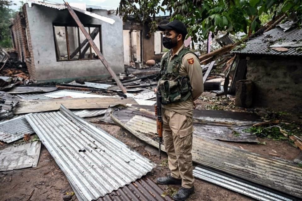 Un miembro del personal de seguridad permanece junto a una casa destruida por el bombardeo de artillería pakistaní en la aldea de Salamabad, en Uri.