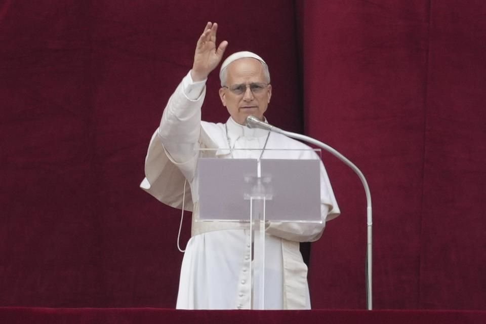 El Papa León XIV da su bendición desde el balcón central de la basílica de San Pedro en su primera bendición dominical.