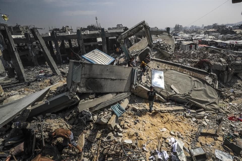 Palestinos caminan entre escombros tras un ataque israelí en la Ciudad de Gaza, el 10 de mayo del 2025.