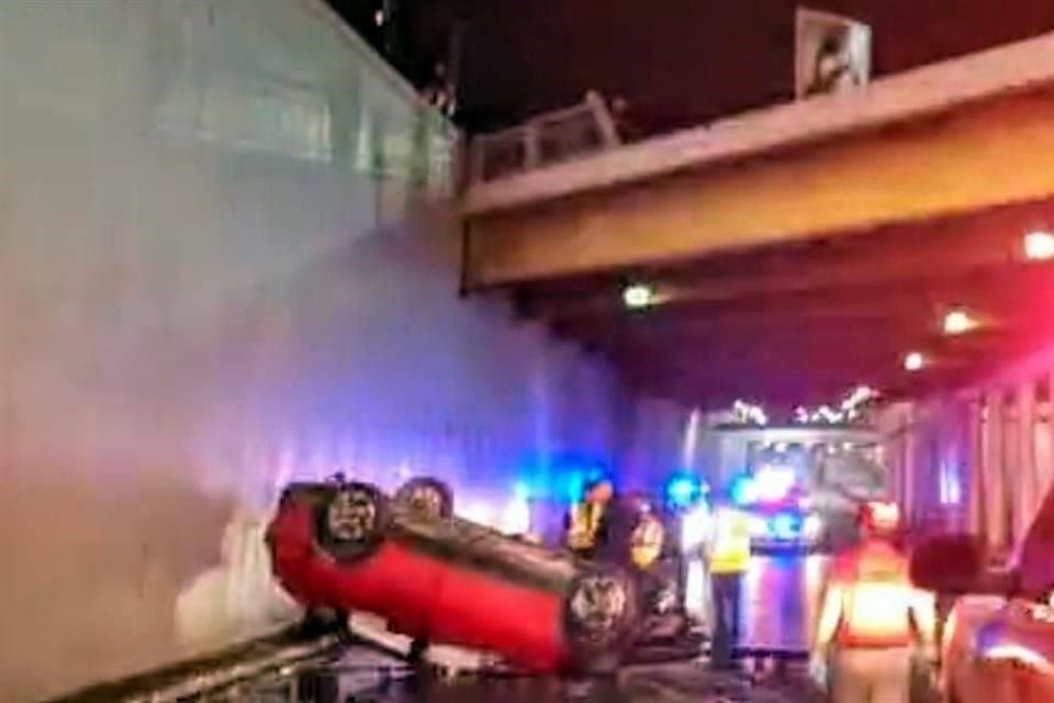 Al derribar el barandal, el auto cayó a los carriles inferiores del puente, quedando con las llantas hacia arriba.