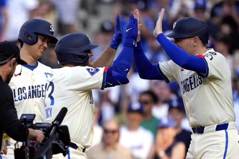 Max Muncy (centro) es felicitado tras impulsar a sus compañeros.