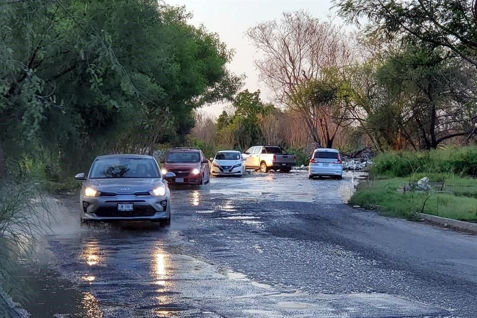 Los vehículos intentan sacarle la vuelta a los baches que se empeoraron por la fuga.