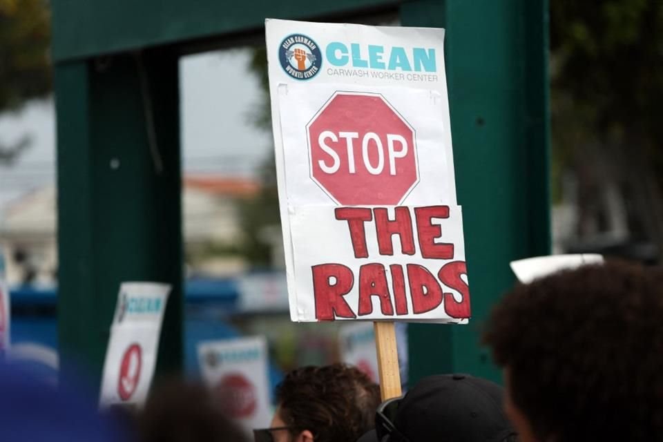 Personas sostienen carteles que piden el fin de las redadas de migración durante una marcha en California.