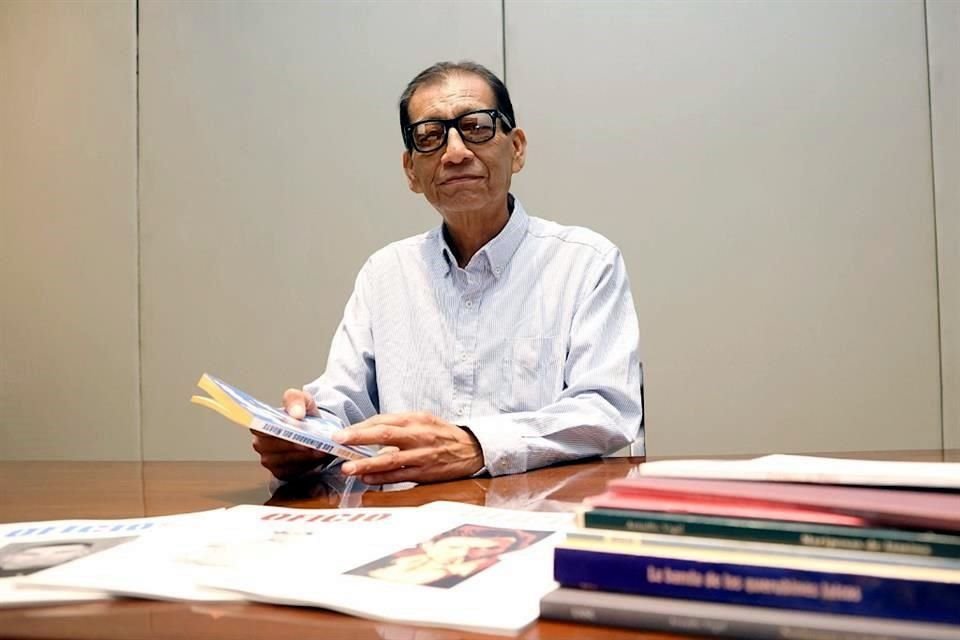 Arnulfo Vigil posando junto a sus libros.