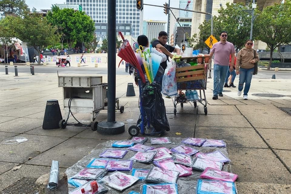 En las banquetas contiguas al Monumento a la Revolución se ubican comerciantes con mercancía en el suelo.  