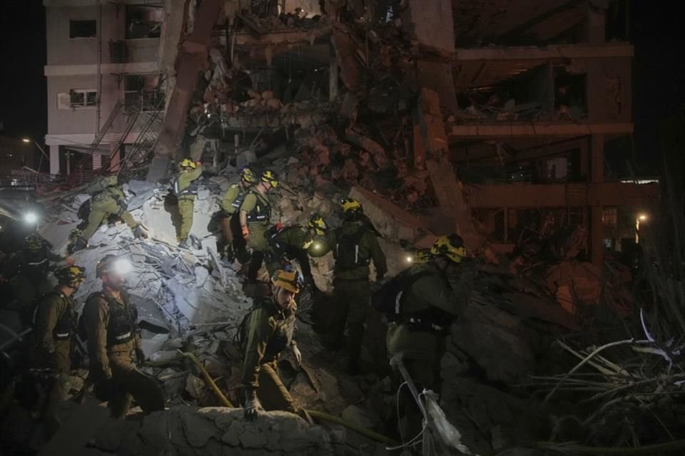 Fuerzas de seguridad inspeccionan un edificio destruído por un misil disparado desde Irán, el 15 de junio.