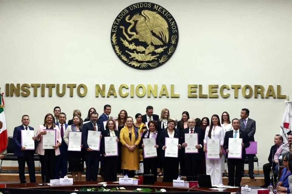 Los nuevos magistrados posan con la presidenta del INE, Guadalupe Taddei, tras recibir las constancias que acreditan sus triunfos.
