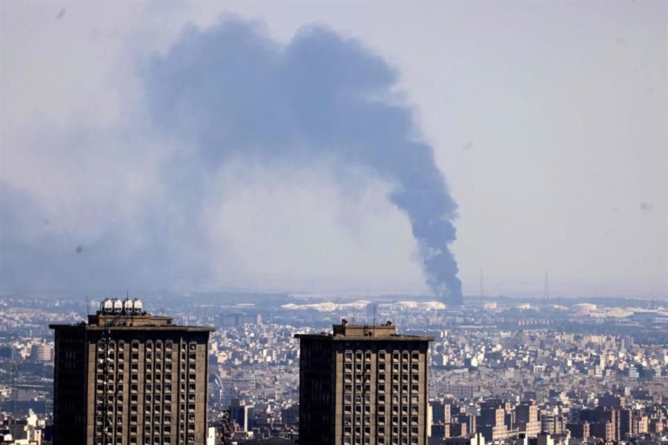 Una columna de humo se eleva a lo lejos desde una refinería de petróleo tras un ataque israelí contra la capital iraní, Teherán, el 17 de junio de 2025.