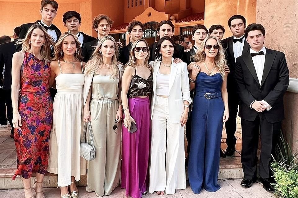 Un grupo de graduados con sus mamás.