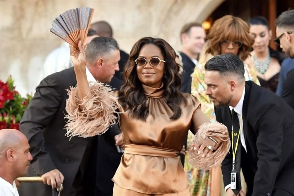 Oprah Winfrey en un atuendo cobrizo saludó a los fotógrafos.