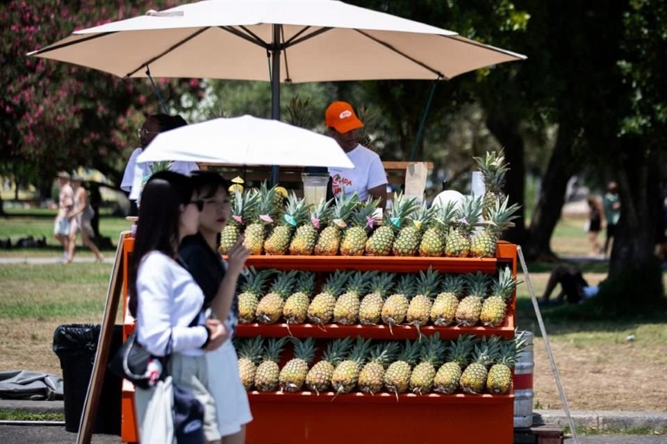 Dos mujeres se protegen con una sombrilla del sol en los jardines de la Torre de Belem, en Lisboa.