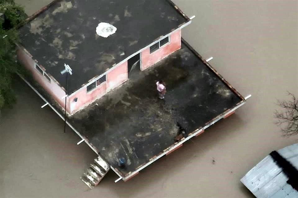 En redes sociales circulan imágenes de una familia atrapada en la azotea de una vivienda inundada.