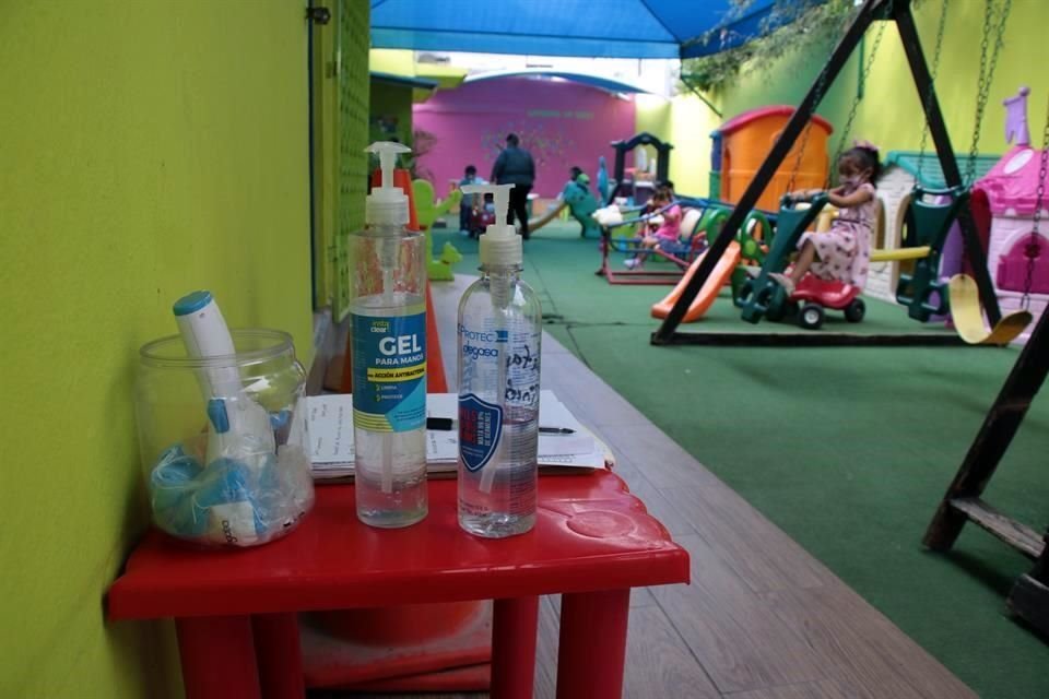 Los alumnos se colocan gel antibacterial antes de ingresar al edificio para instalarse en sus clases.