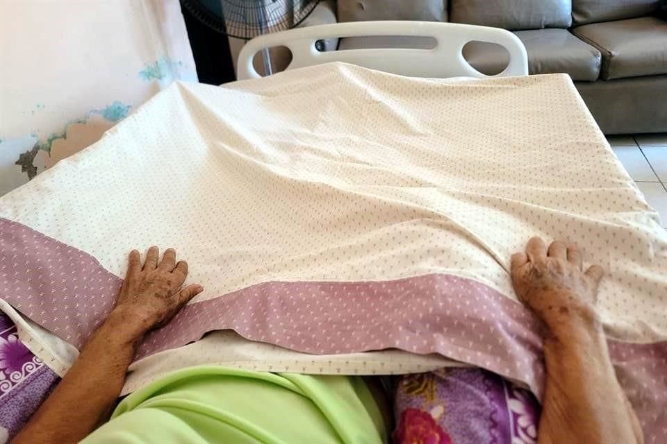 বার্টা হার্নান্দেজ, 90 বছর বয়সী, বাড়িতে কনভেলসের, এর সহায়তা এবং সুবিধার জন্য অপেক্ষা করছেন।
