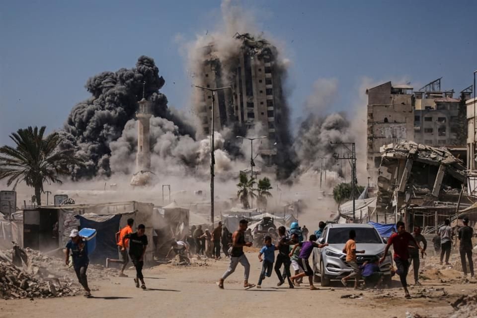 Gente corre para cubrirse durante un ataque israelí a un edificio alto en Ciudad de Gaza, el viernes 5 de septiembre.
