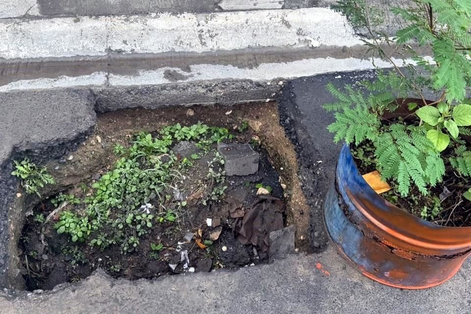 En otro pozo vecinos colocaron una maceta para alertar a peatones y automovilistas.
