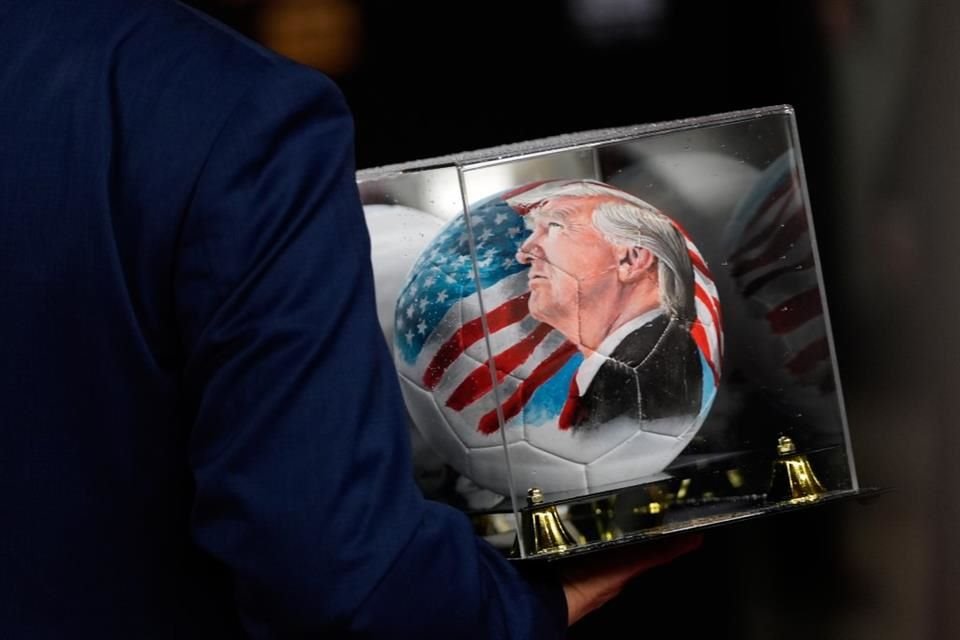 Una persona carga un balón con el rostro del Presidente Trump.