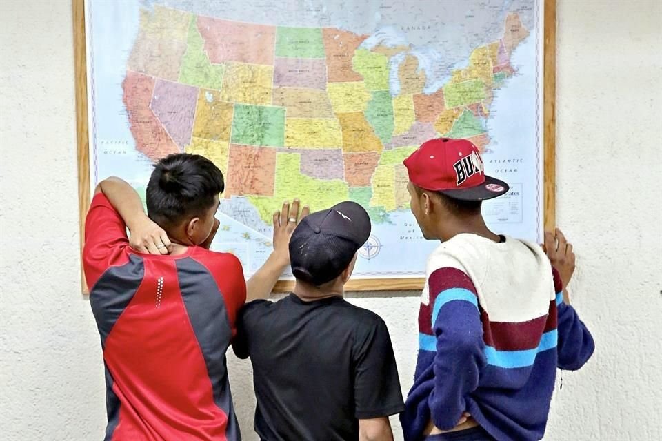 Migrantes que mantienen su sueño de llegar a Estados Unidos observan en un mapa las rutas que pueden seguir.