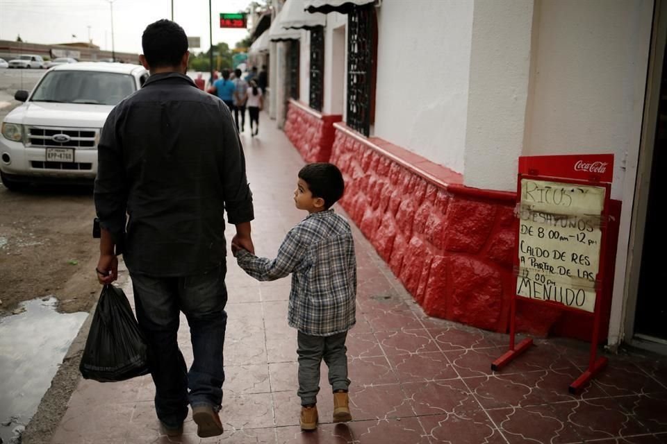 Un migrante hondureño y su hijo caminan en Ciudad Juárez después de poner una solicitud de asilo en la frontera.