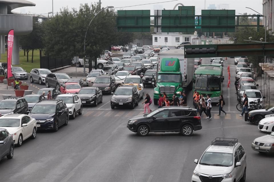 Autos en doble y triple fila para ingresar a los estacionamientos de Cintermex ocasionaron congestionamientos viales, pese a la presencia de al menos 10 elementos de Tránsito. 