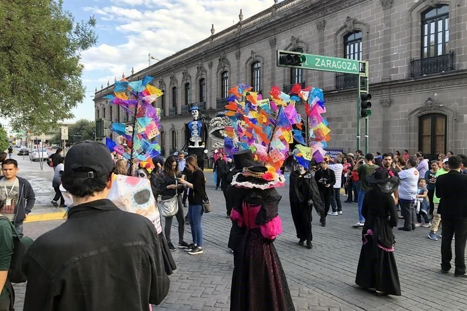 Varias personas disfrazadas de catrinas acompañan la marcha de las calaveras.