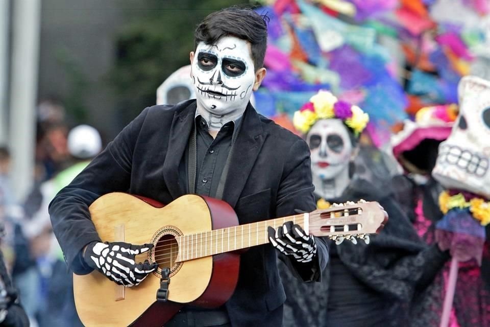Cientos de personas desfilaron caracterizados con maquillajes y vestuarios tradicionales de la festividad mexicana de Muertos.