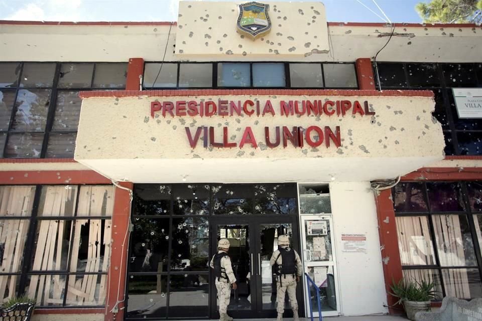 Militares vigilan la Presidencia Municipal de Villa Unin, que luce acribillada por el ataque de grupos criminales.
