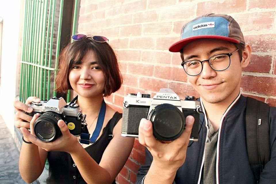 Ana María Rodríguez, de 22 años, y Luis Andrés García, de 21 años, toman sus fotografías con cámara análoga.