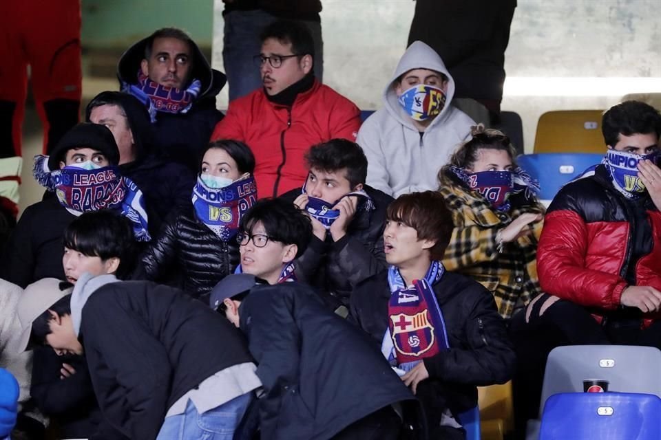 Algunos aficionados en San Paolo se cubrieron la boca por el brote de coronavirus en Italia.