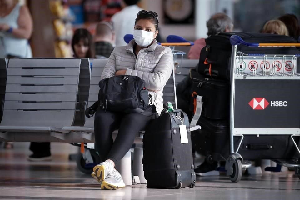 Pasajeros usan cubrebocas para protegerse del coronavirus mientras transitan por el Aeropuerto Internacional de Ezeiza, en Buenos Aires.