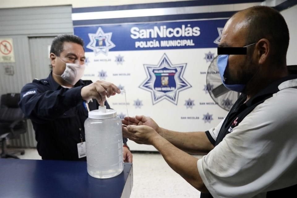 Policías municipales y del Estado ponen cubrebocas y gel antibacterial a los detenidos ante la amenaza del coronavirus.