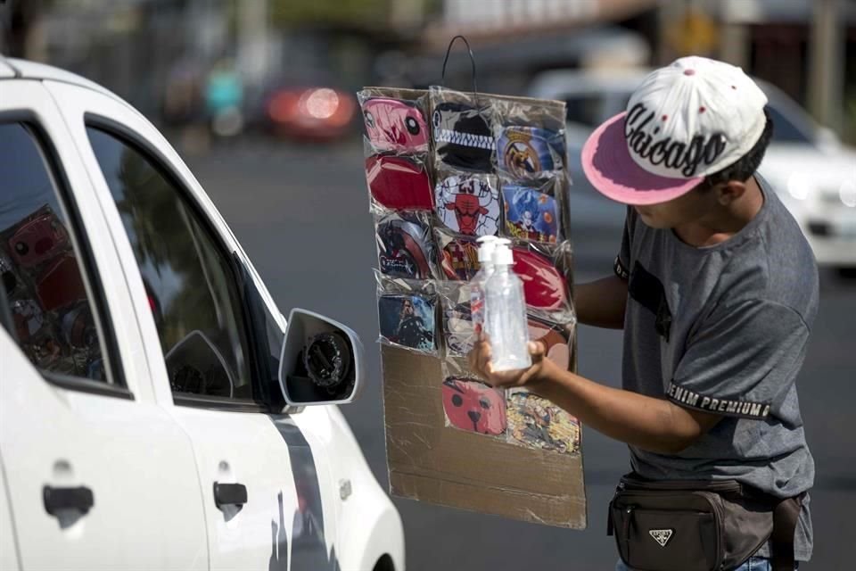 Un joven vende mascarillas de tela y gel antibacterial en Managua como medida de prevención contra la propagación del coronavirus.