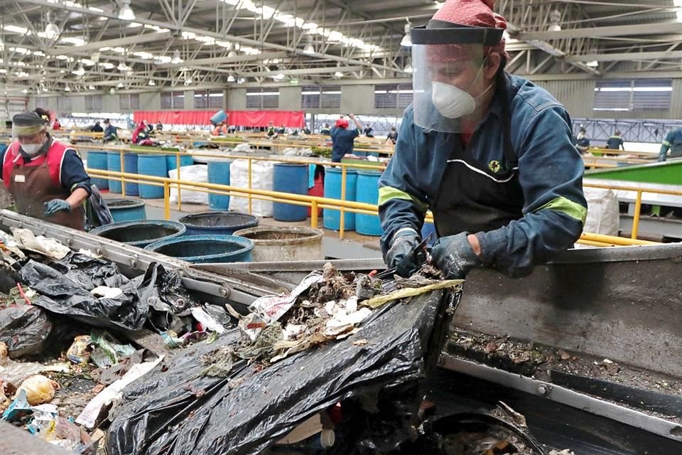 Con un cuchillo en mano, los trabajadores abren las bolsas del plástico para encontrar metales, plásticos y vidrios.